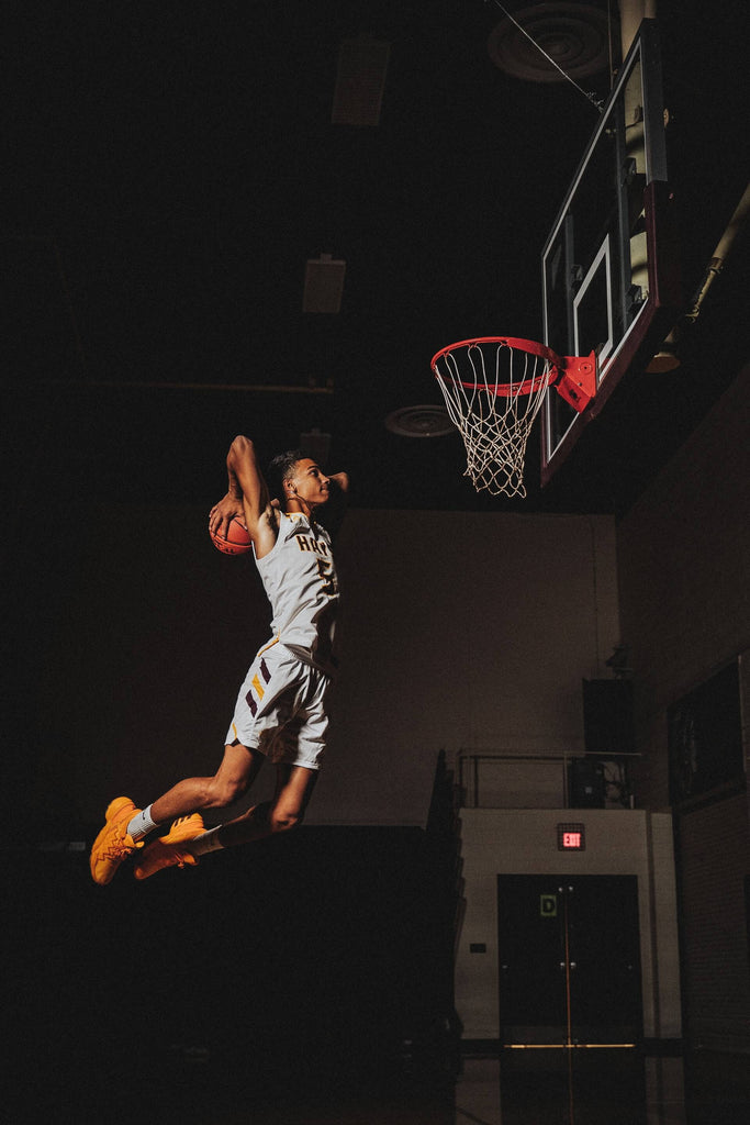 man doing slam dunk playing basketball