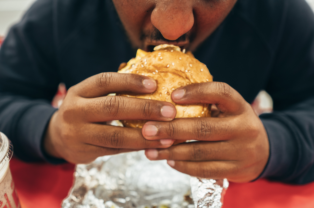 man biting into a burger