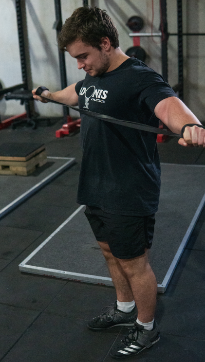 man using black resistance band in gym