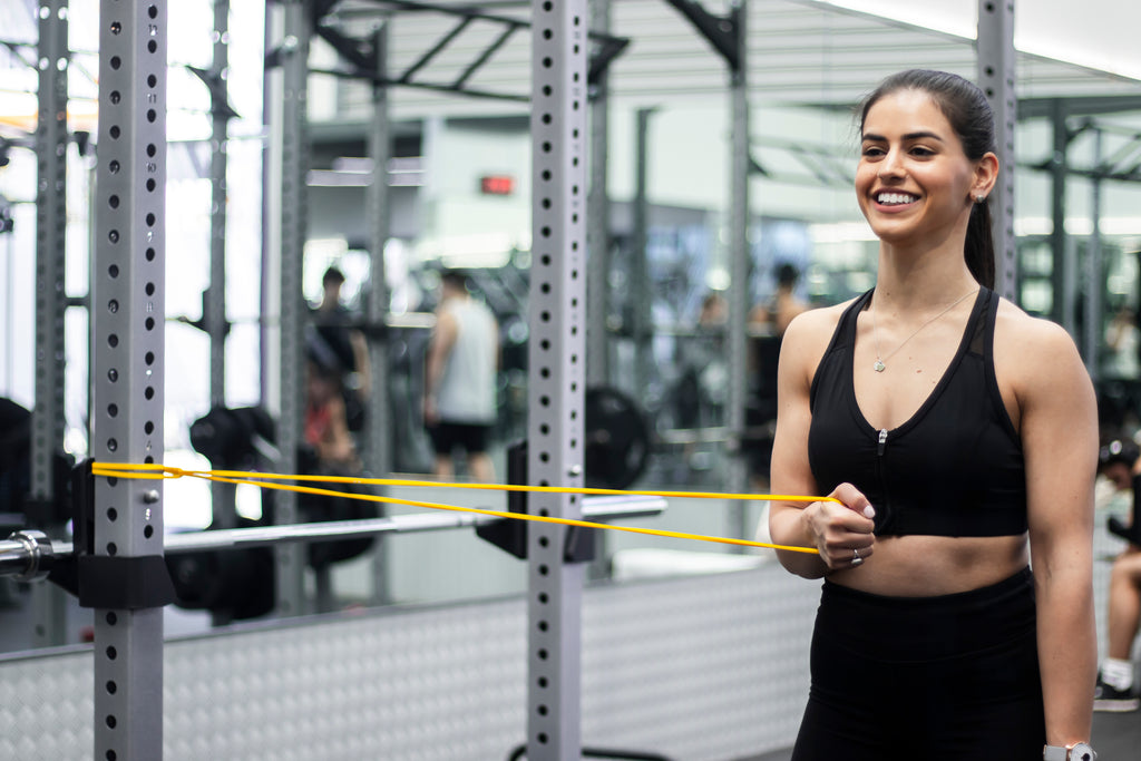 girl using yellow resistance band in gym